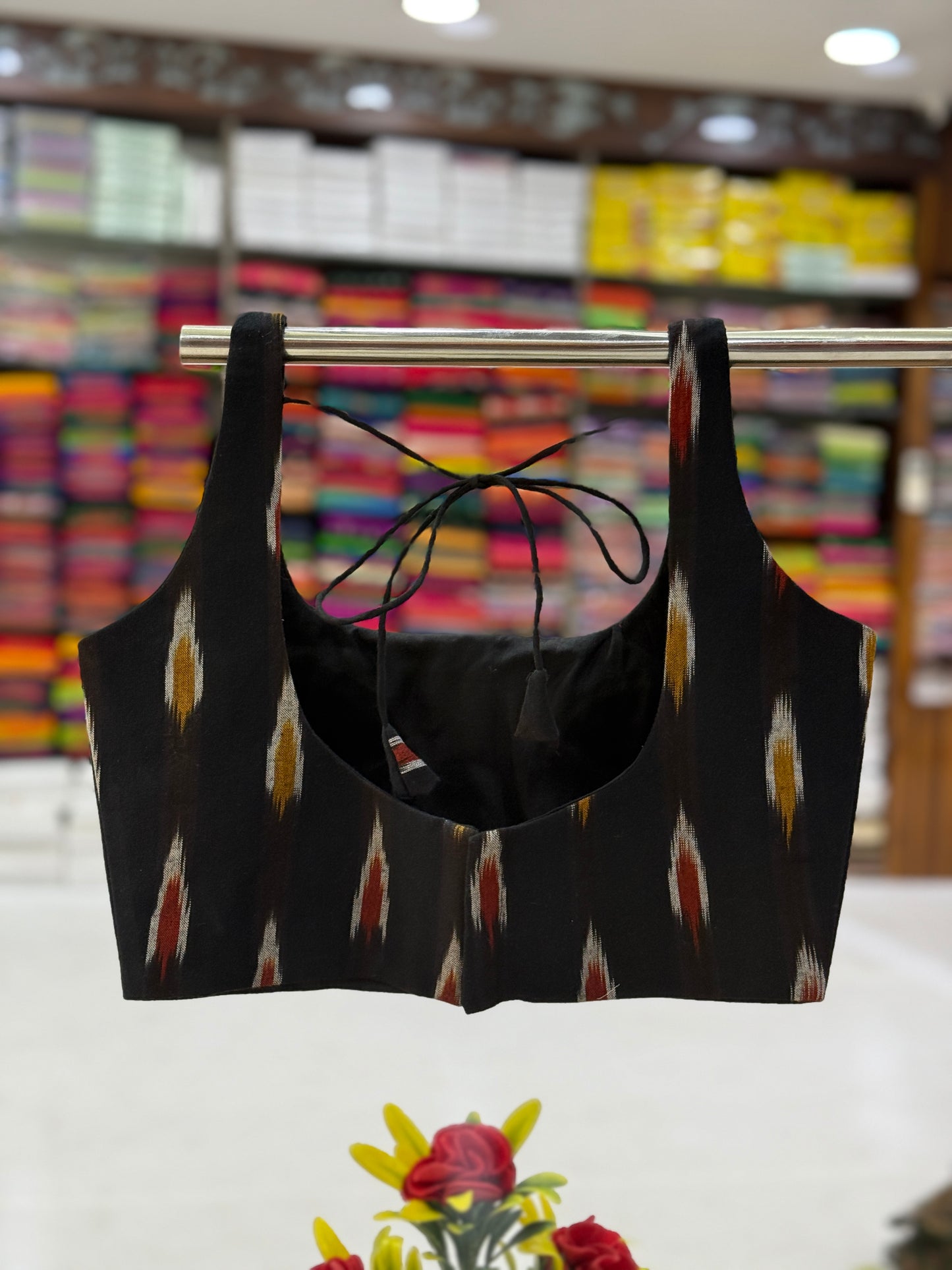 Black Ikat blouse showcasing a scooped neckline with a tie-up detail, featuring traditional handwoven patterns